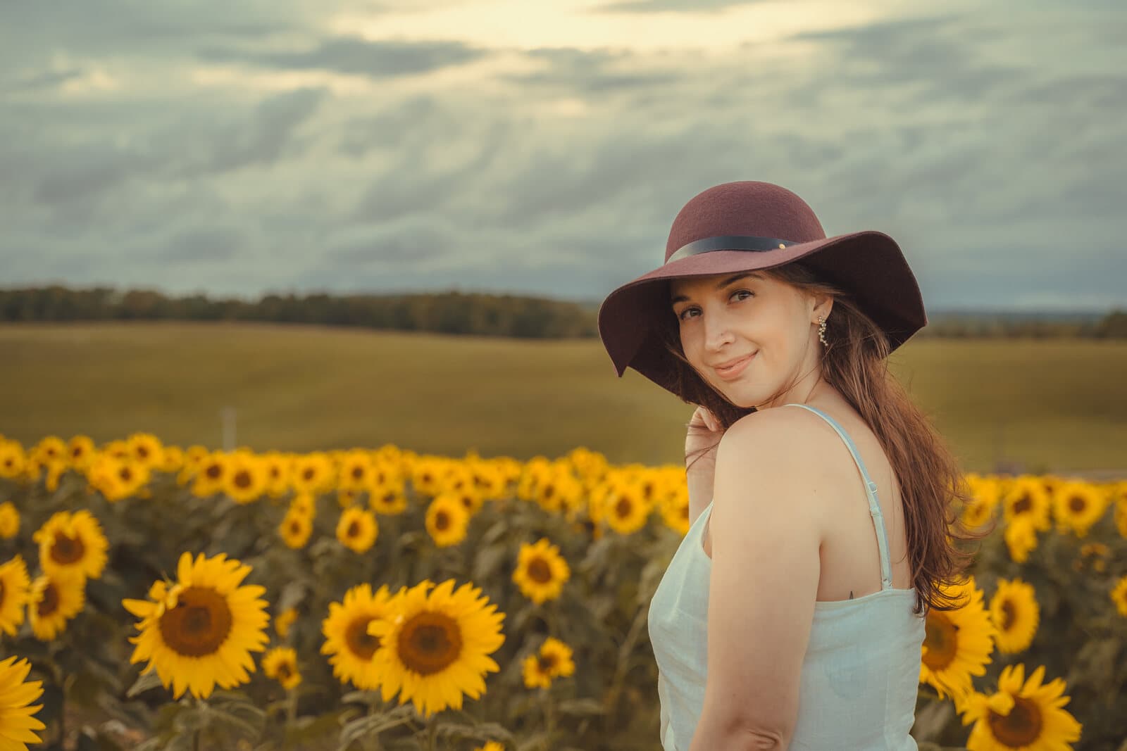 Editorial portrait in a sunflower field at golden hour
