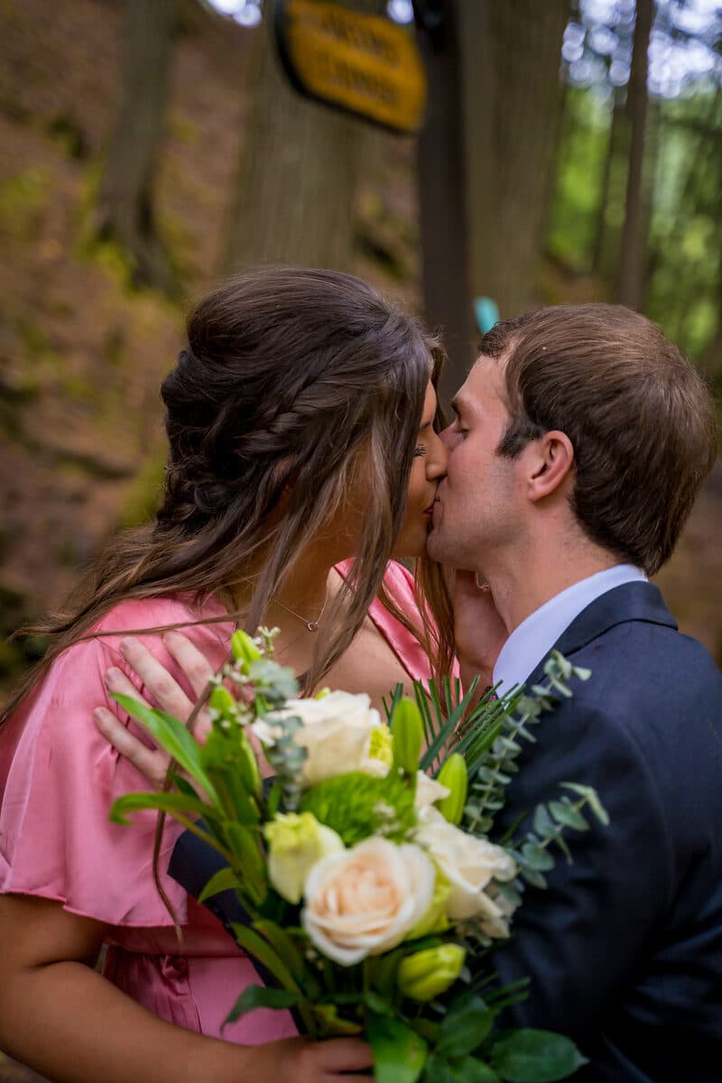 Bride and groom kissing among autumn foliage, Nova Scotia wedding