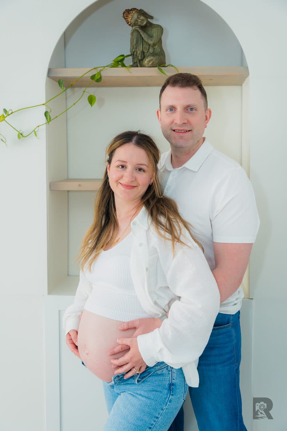Expectant couple laughing together during a home maternity session