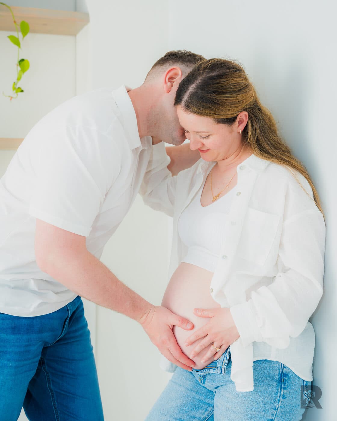 Expectant couple forehead to forehead during an at-home maternity session