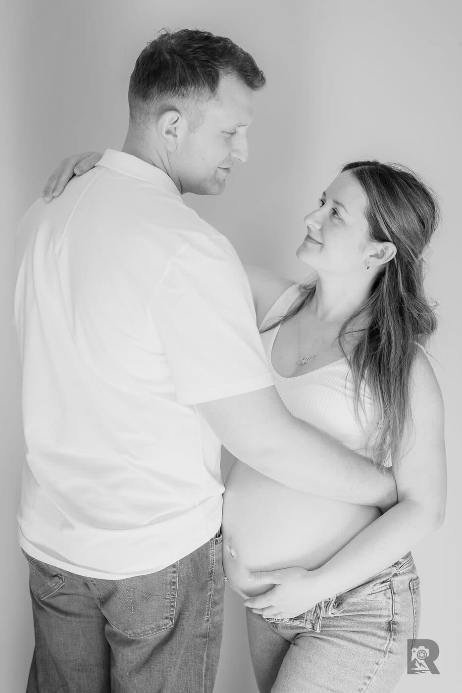 Black and white at-home maternity portrait of an expectant couple
