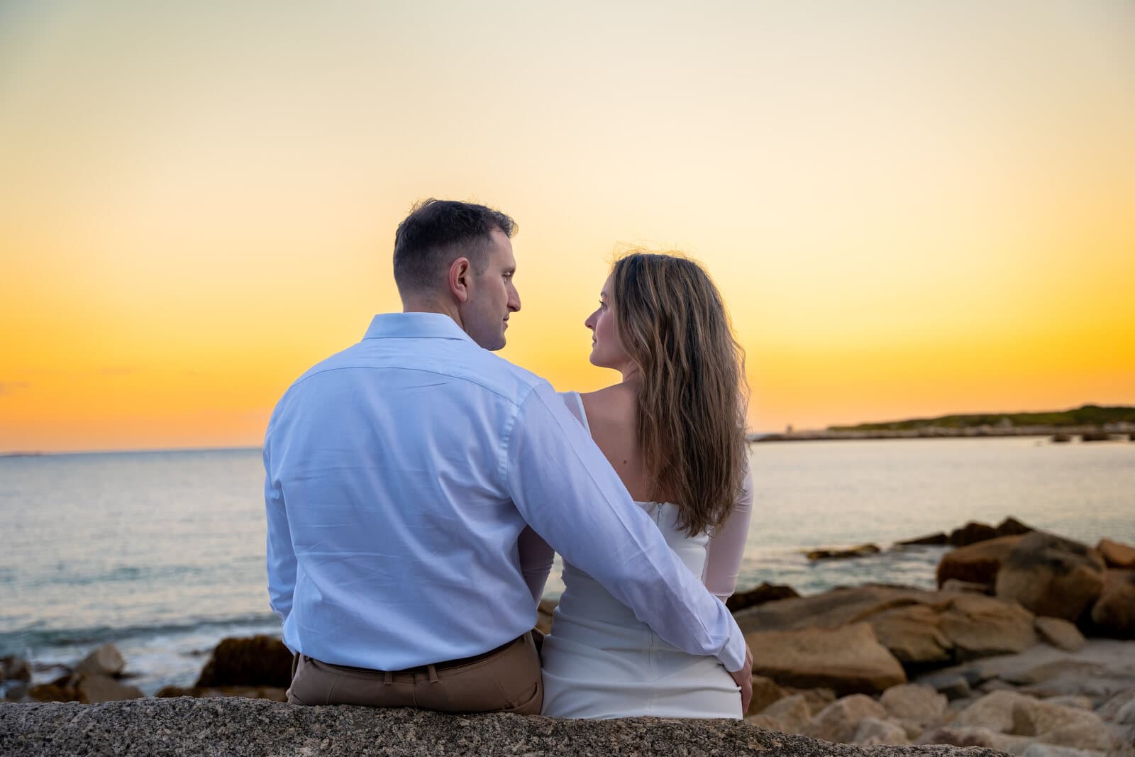 Engaged couple watching the sunset on a Nova Scotia coastline