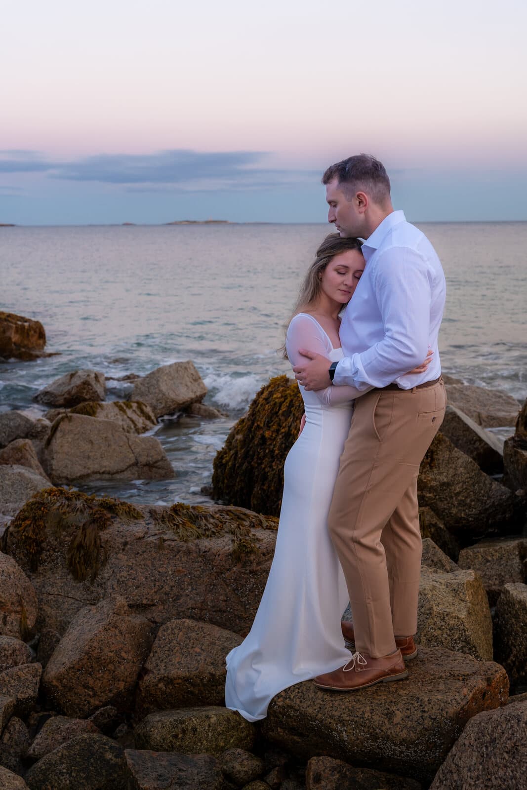 Engaged couple embracing on the shoreline, Nova Scotia