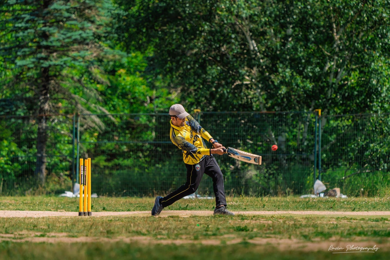 Cricket batter mid-swing, ball in flight, Halifax match