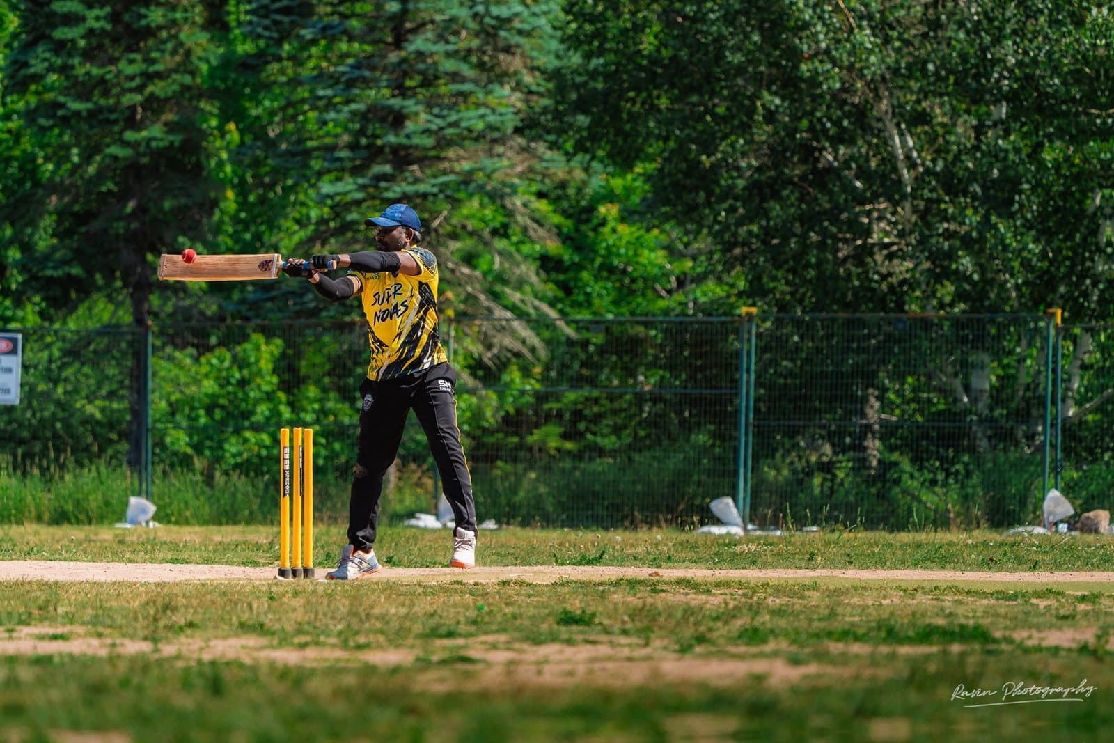 Cricket batter mid-swing photographed from a low side angle, Halifax match