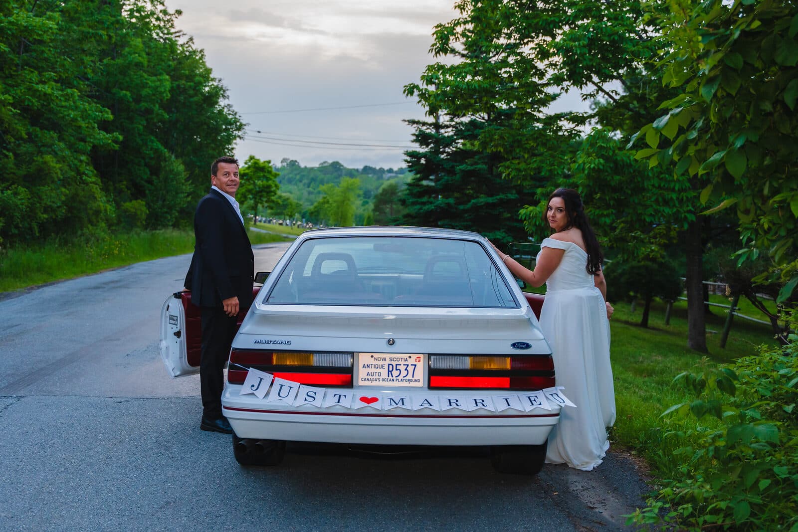 Bride and groom with a classic car on a Nova Scotia road